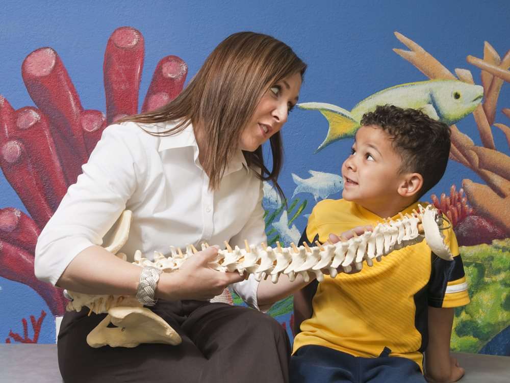 Chiropractor explaining to child