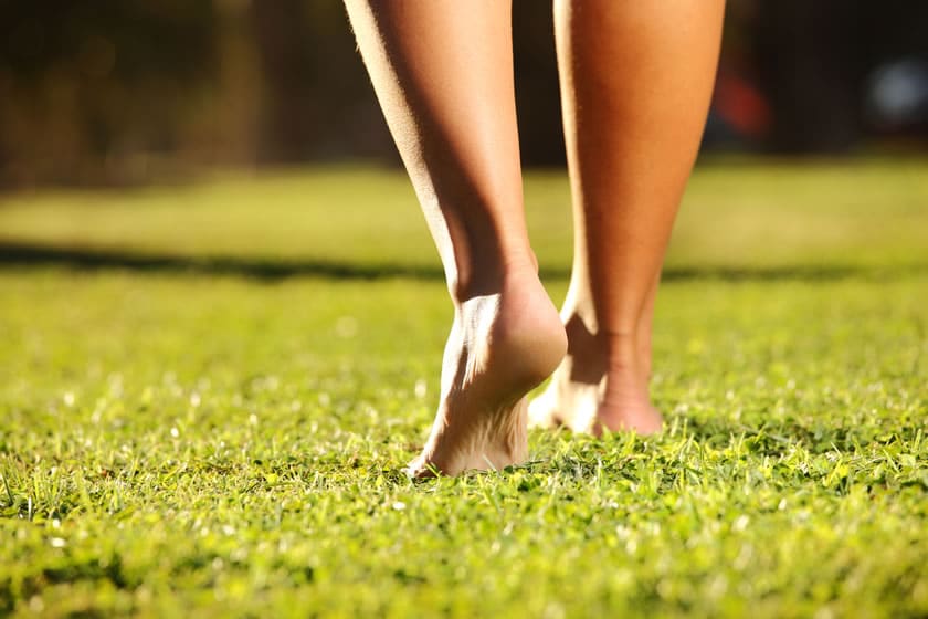 woman walking bare foot on grass