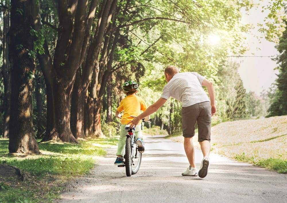 Father helping his son ride a bicycle