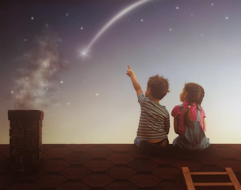 children sitting on roof watching the stars