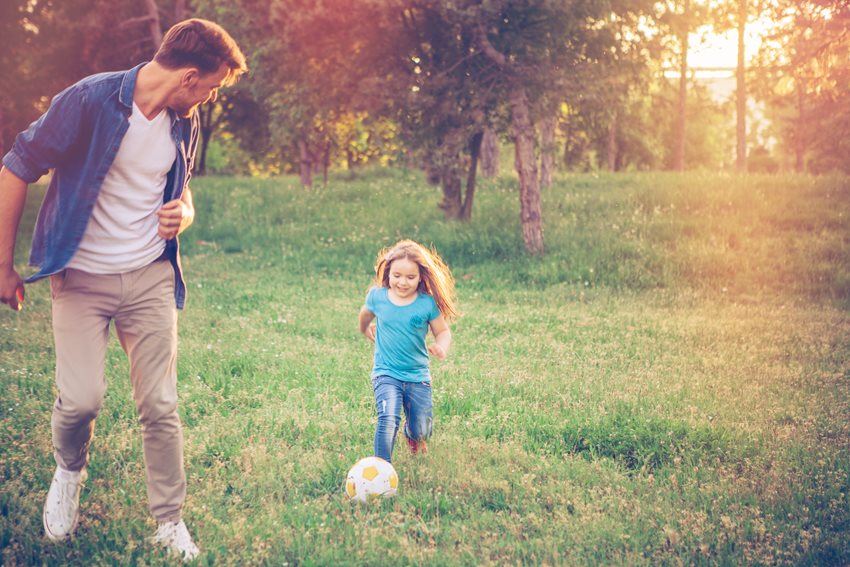 dad playing football with his daughter